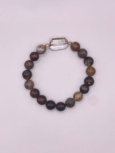 A bracelet with round brown and multicolored agate stones and a clear crystal center charm.
