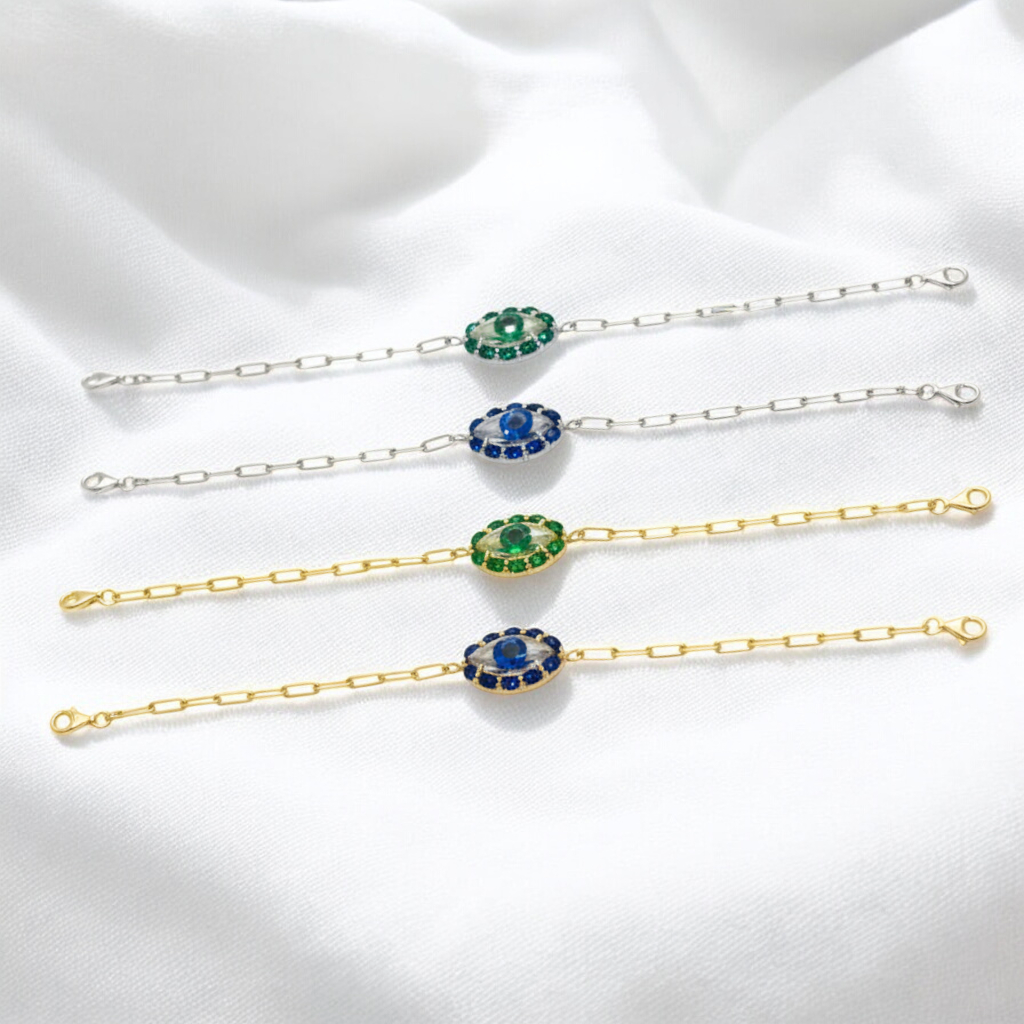 Set of gold and silver bracelets with gemstone accents on a white fabric background