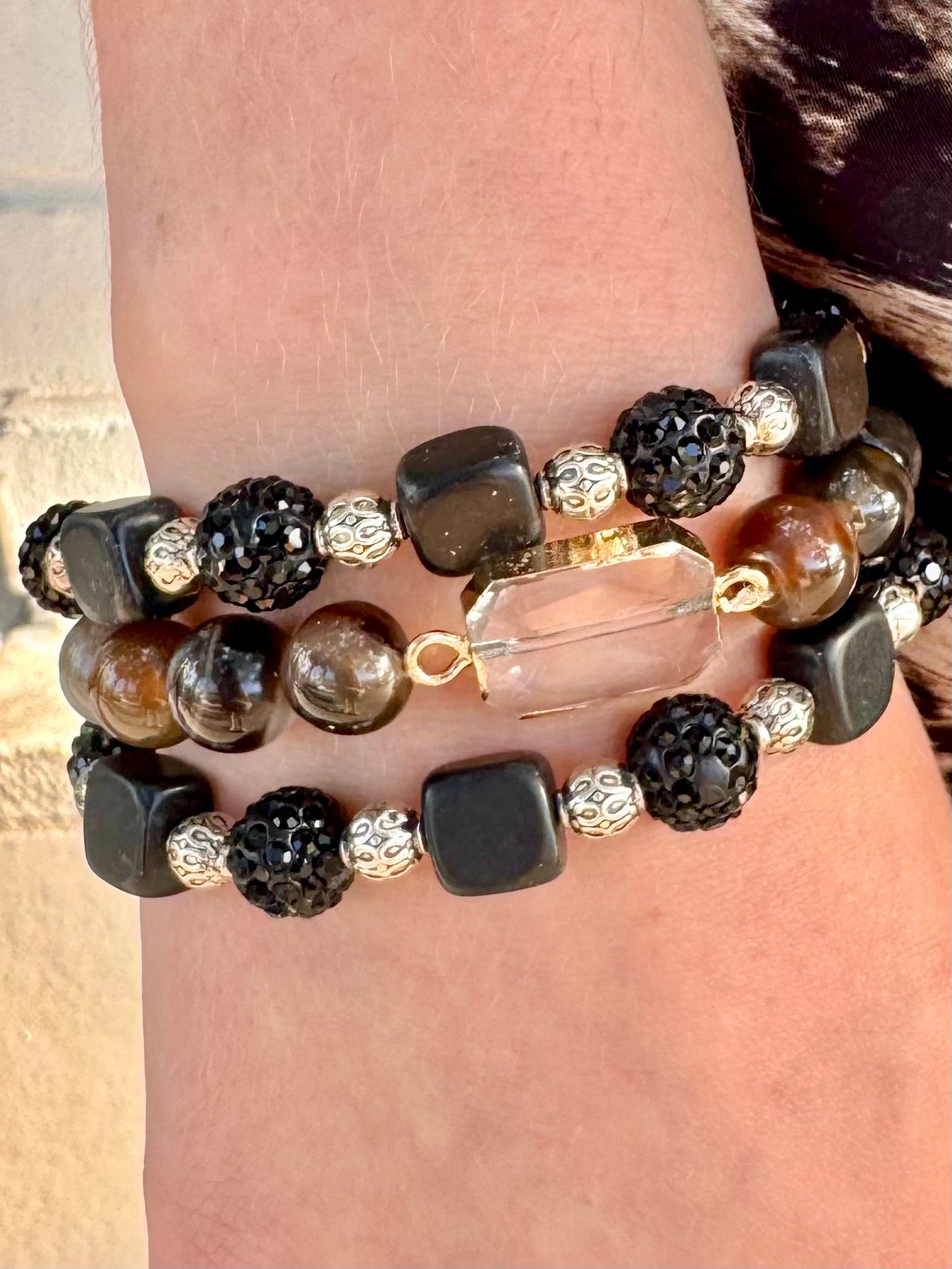 Stack of beaded bracelets on a wrist with a neutral background